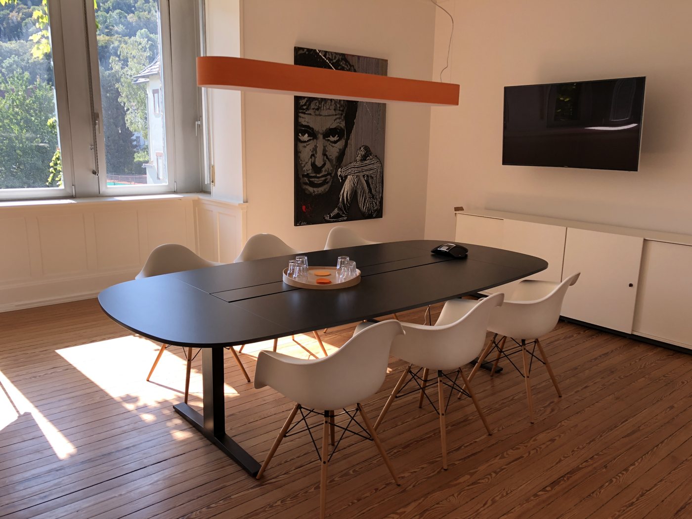 Meeting room with a large table and an orange pendant light